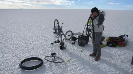Une tranche de vie de cyclotouriste : réparation de crevaison au petit matin, dans un désert de sel. Courage Jenn !