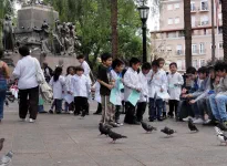 Des écoliers s'amusent avec des pigeons.